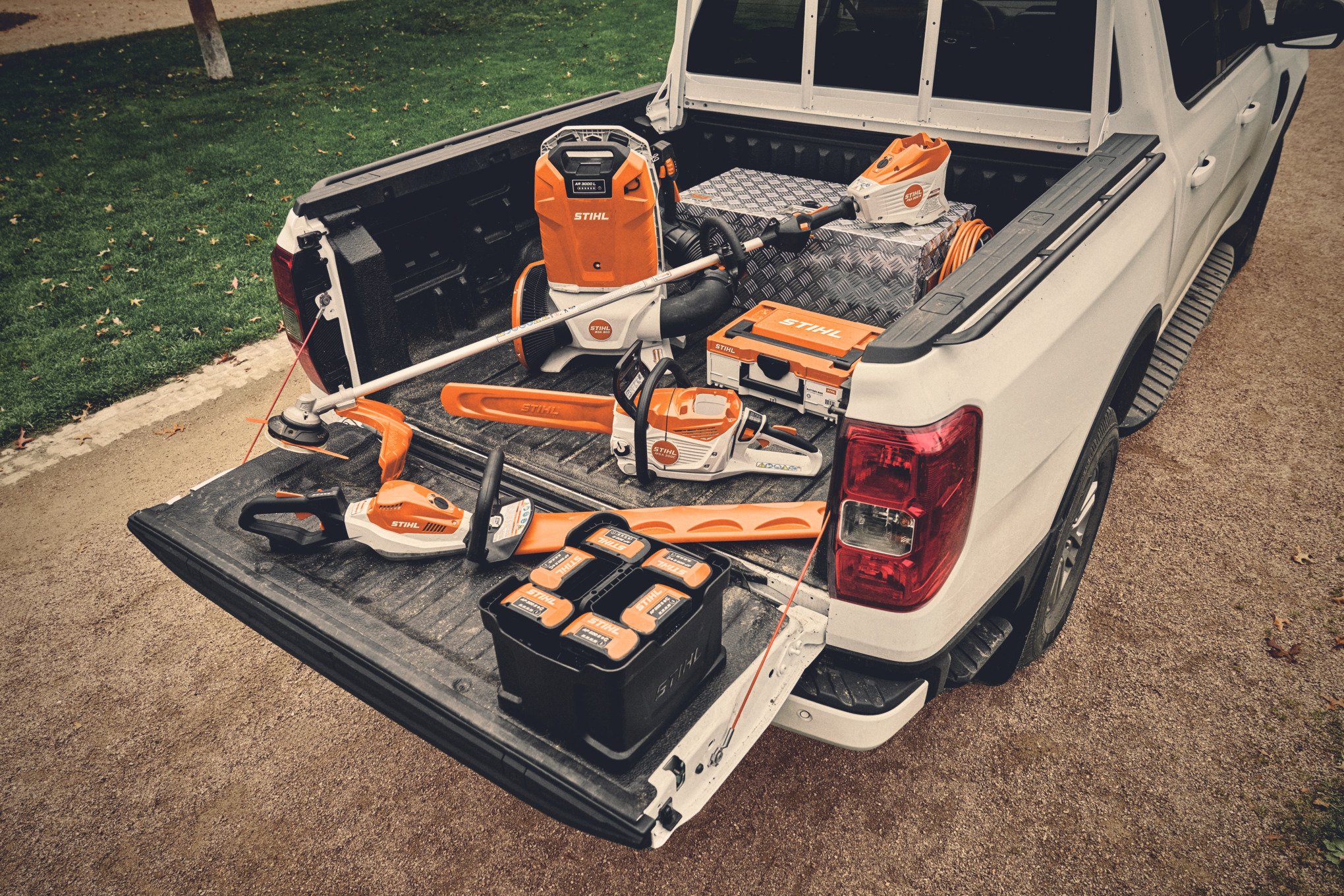 Various battery power tools and matching batteries from the STIHL AP system on the loading bed of a vehicle  