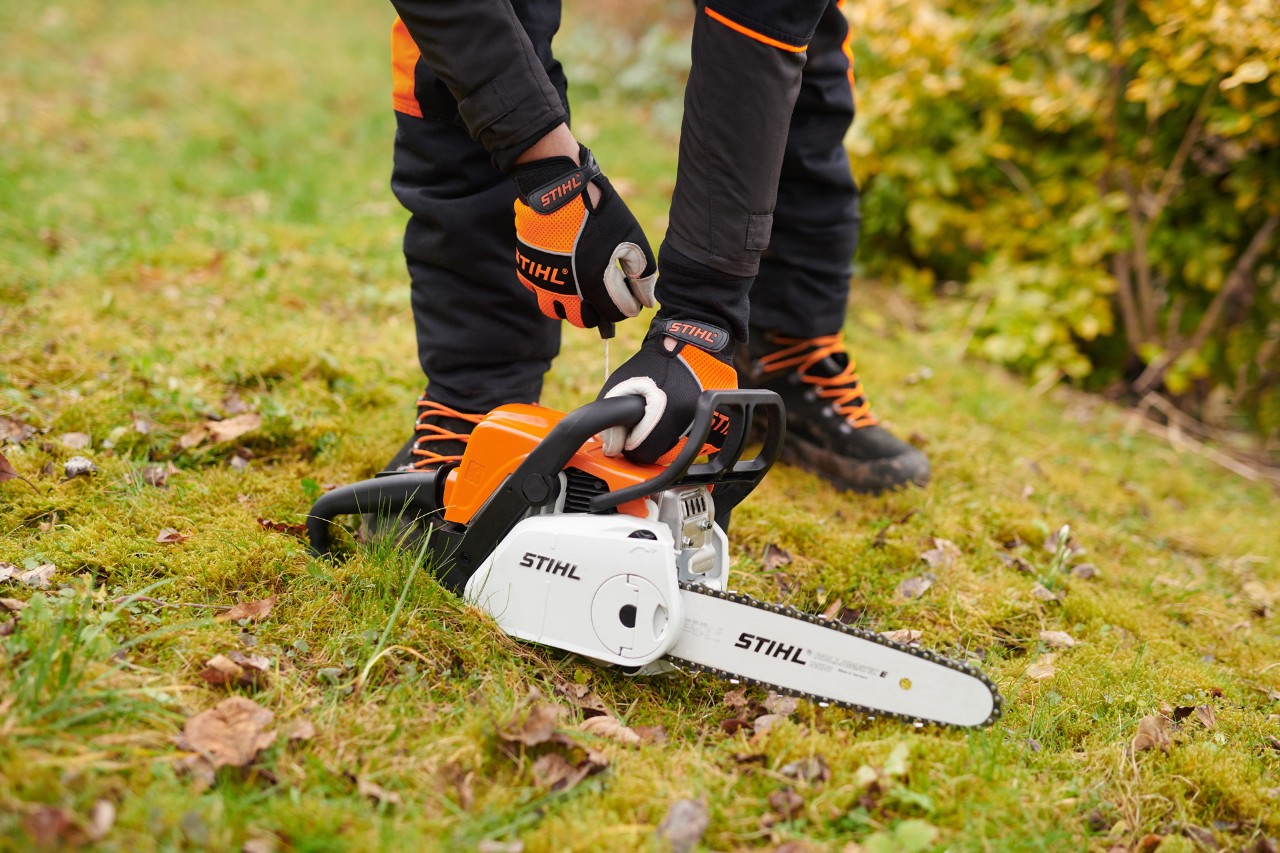 Starting the STIHL MS 180 C-BE petrol chainsaw on the ground