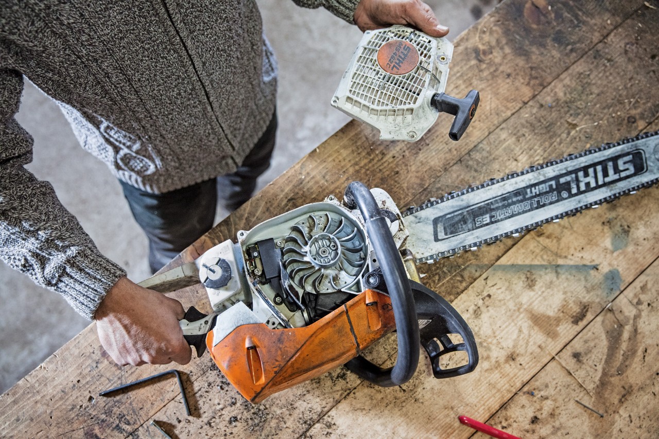 A STIHL MS 462 C-M petrol chainsaw on a workbench with the cover removed