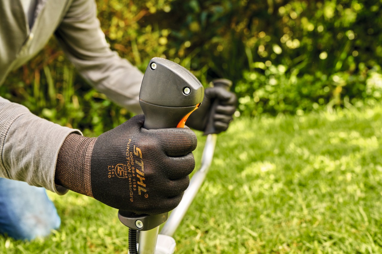 A man initially starting the engine of the STIHL FS 91 petrol brushcutter