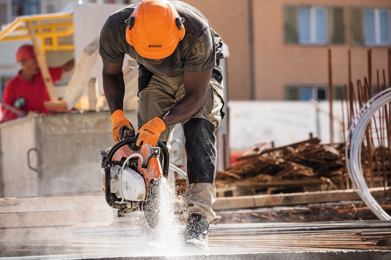 A person in PPE using a cut-off machine