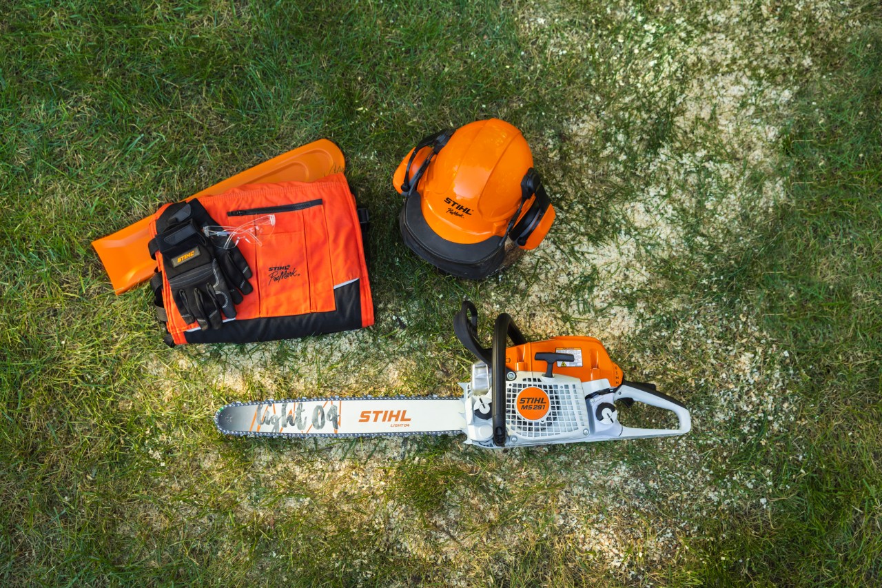 Forestry worker wearing STIHL protective clothing with Dynamic Vent trousers (cut protection class 1) sawing trees in the forest with a STIHL chainsaw