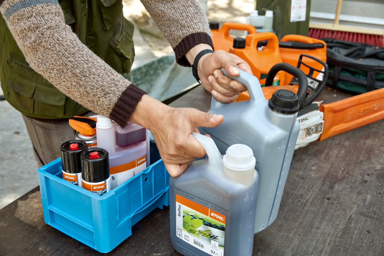 A person tidying up STIHL fuels and lubricants in crates for transport